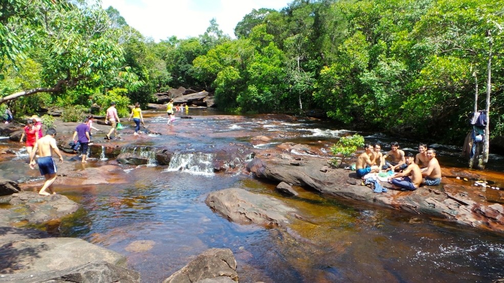 Tourists rest and eat on the rock faces at Da Ban Stream