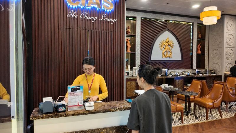 Hành khách mua vé phòng chờ thương gia tại quầy lễ tân