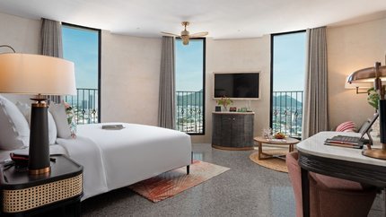 Phòng Deluxe với nhiều cửa kính lớn tại khách sạn.