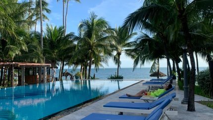 Bể bơi với hàng ghế dài tắm nắng