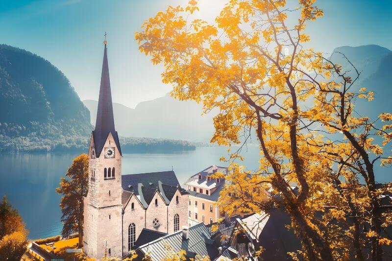 Nhà thờ Hallstatt nổi bật giữa những ngôi nhà cổ, phía xa là núi Alps